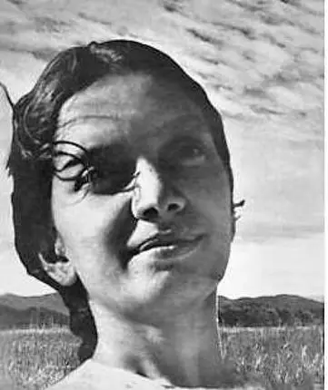 Archival photograph of Kalpana Datta outdoors, with clouds and an open field visible behind her.